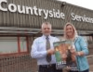 Two people holding a poster and smiling